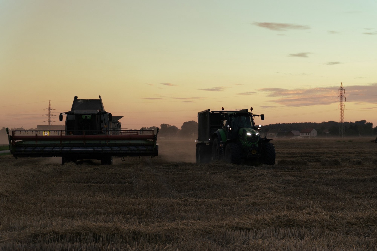 Colheitadeira e trator em operação agrícola ao entardecer